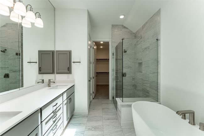 Full bathroom featuring a marble finish shower, double vanity, marble finish floors, a soaking tub, and recessed lighting | Image 26