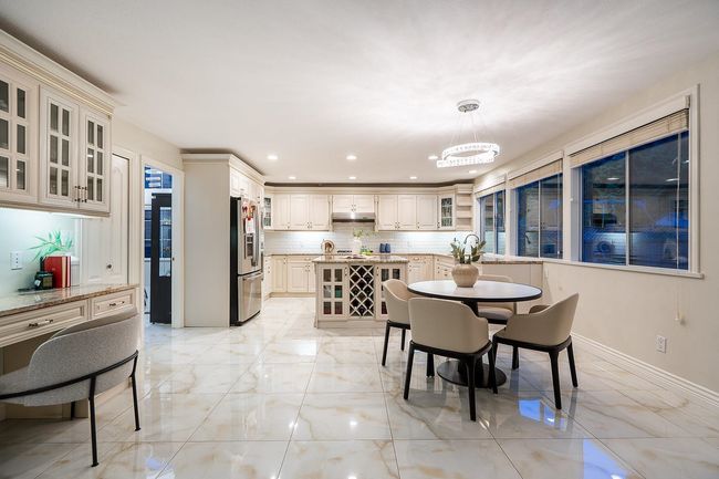 Dining space featuring light marble finish floors, a chandelier, and recessed lighting | Image 10