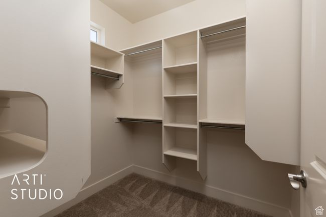 Spacious closet featuring dark colored carpet | Image 25