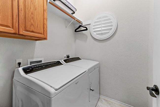 Laundry area featuring cabinets and washing machine and clothes dryer | Image 27