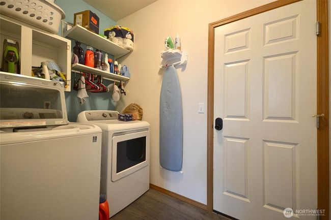 Laundry room with shelves and door to the garage | Image 21