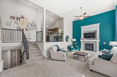 Carpeted living room with ceiling fan and high vaulted ceiling | Image 3