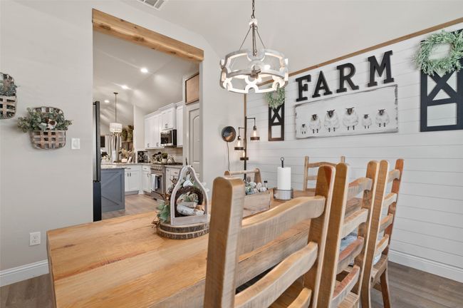 Dining area featuring vaulted ceiling, a chandelier, and light wood-style flooring | Image 6
