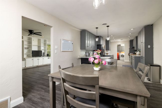 Dining area featuring washing machine and dryer, visible vents, and dark wood finished floors | Image 10