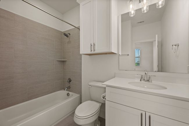 Bathroom with bathtub / shower combination, visible vents, vanity, and toilet | Image 34