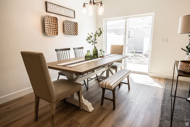 Dining space featuring wood finished floors and a chandelier | Image 4