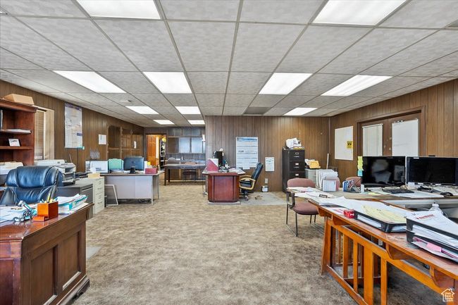 Office area featuring a paneled ceiling, carpet flooring, and wood walls | Image 16
