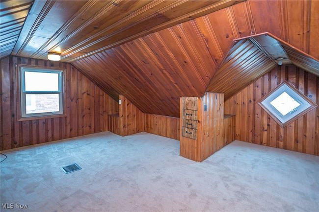 Bonus room with vaulted ceiling, wood walls, and carpet flooring | Image 30