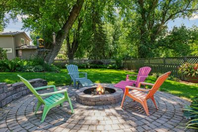 Inside the fenced backyard you’ll find several brick patio areas, a beautiful waterfall and raised gardening tubs (not shown). Enormous windows, a four season sunroom & expansive deck provide additional relaxation areas and gorgeous park-like views. | Image 3