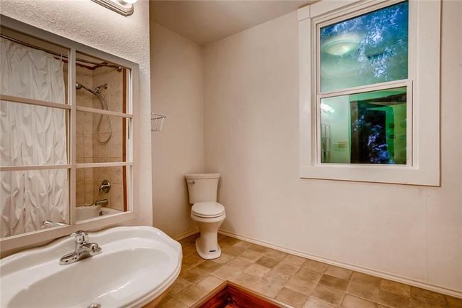 Bathroom with a sink, toilet, shower / washtub combination, and baseboards | Image 18