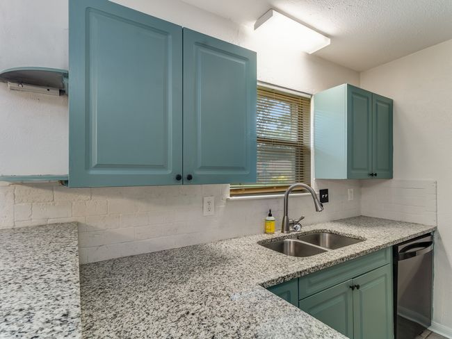 Kitchen featuring dishwashing machine, backsplash, and light stone counters | Image 13