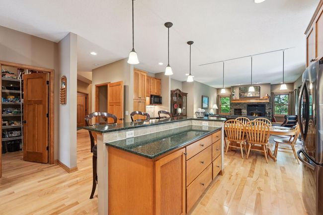 The kitchen island offers valuable storage space, counter space, and seating for informal dining or entertaining. The walk-thru pantry is just steps away. | Image 6