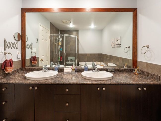 Full bathroom featuring a bath, double vanity, a sink, and a stall shower | Image 28