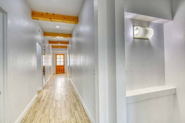 Corridor with beam ceiling and light hardwood / wood-style floors | Image 8