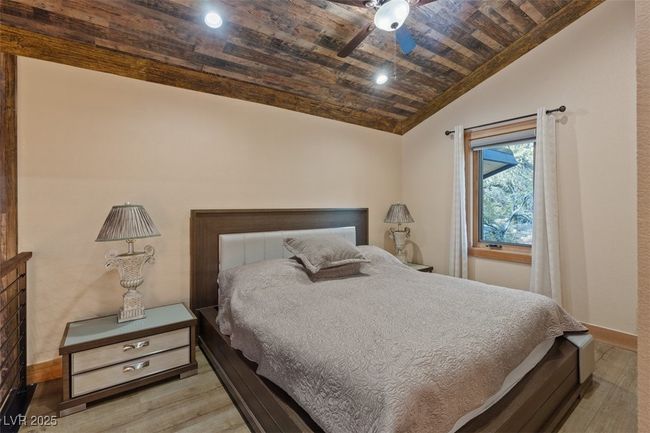 Bedroom featuring wood ceiling, vaulted ceiling, baseboards, and wood finished floors | Image 20