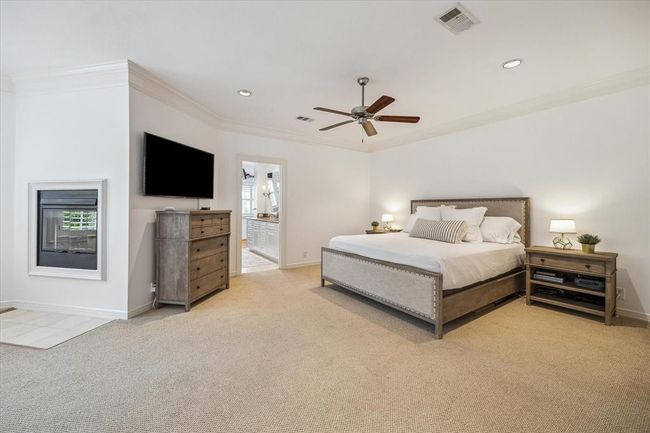 Oversized primary bedroom with adjacent sitting area and dual sided gas log fireplace. Hardwood floors that match the rest of the second story are under the carpet!!!! | Image 17