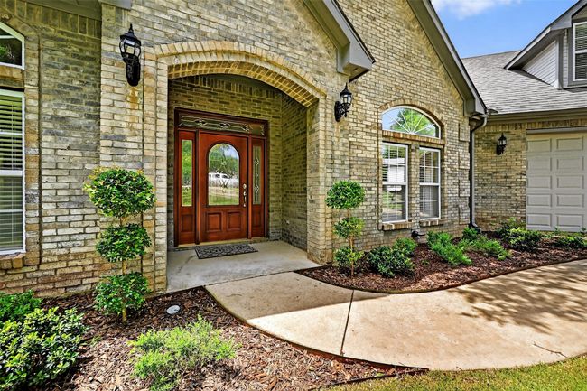 View of exterior entry featuring brick siding, roof with shingles, and an attached garage | Image 5