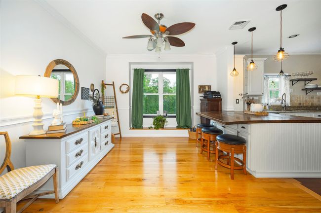 Kitchen featuring light wood-type flooring, butcher block counters, ceiling fan, plenty of natural light, and ornamental molding | Image 10