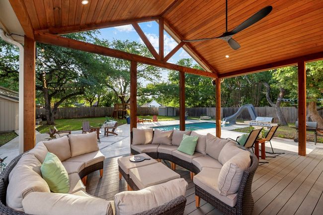 Wooden terrace featuring a fenced backyard, an outdoor living space, and a shed | Image 31