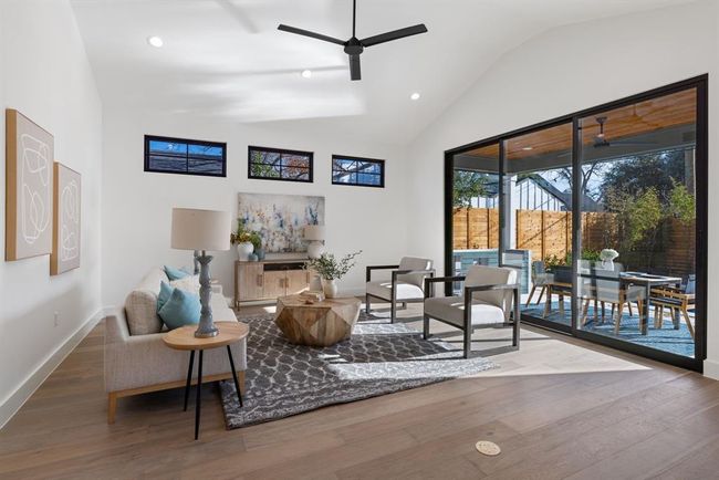 Sitting room featuring a ceiling fan, baseboards, high vaulted ceiling, wood finished floors, and recessed lighting | Image 21