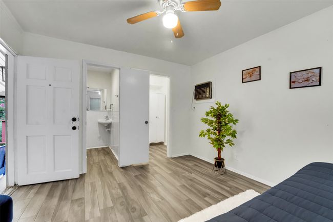 Unfurnished bedroom with light wood finished floors, ceiling fan, and connected bathroom | Image 36