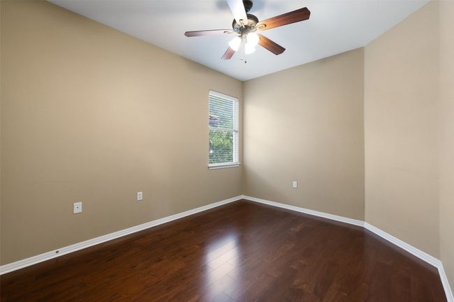 Spare room featuring dark wood-style flooring, baseboards, and a ceiling fan | Image 29