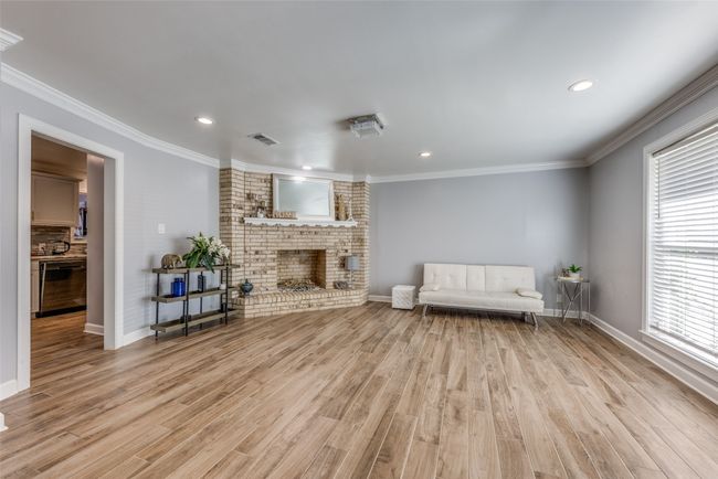 Living room featuring a brick fireplace, light wood-type flooring, recessed lighting, and ornamental molding | Image 5