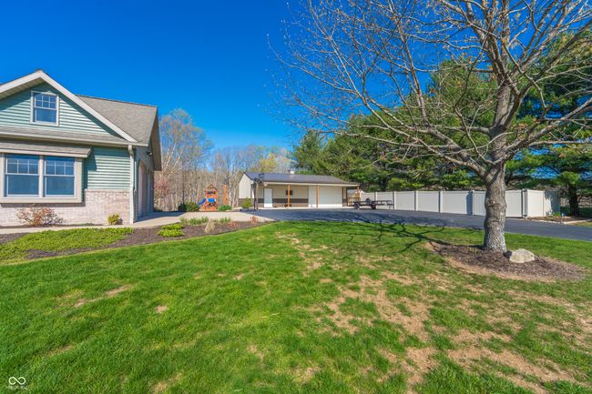 view of yard featuring a detached garage, fence, and aphalt driveway | Image 36