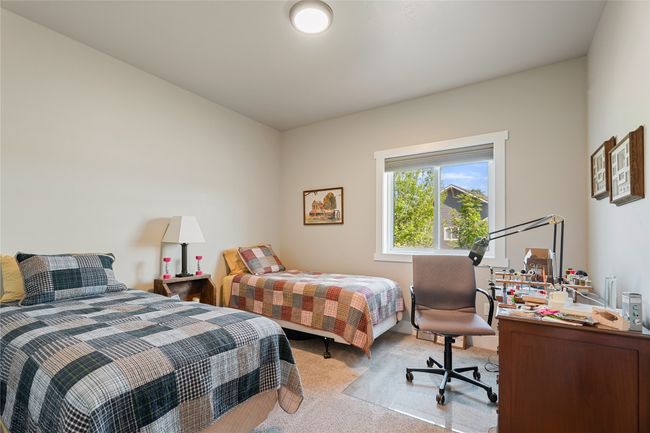 Bedroom with light colored carpet and an office area | Image 22