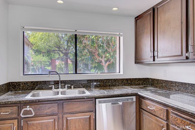 Kitchen window has a lovely view of the front courtyard. Note the granite countertops. | Image 14