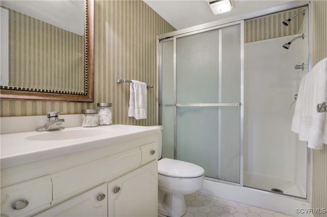 Full bathroom featuring toilet, tile patterned floors, a shower stall, and wallpapered walls | Image 19