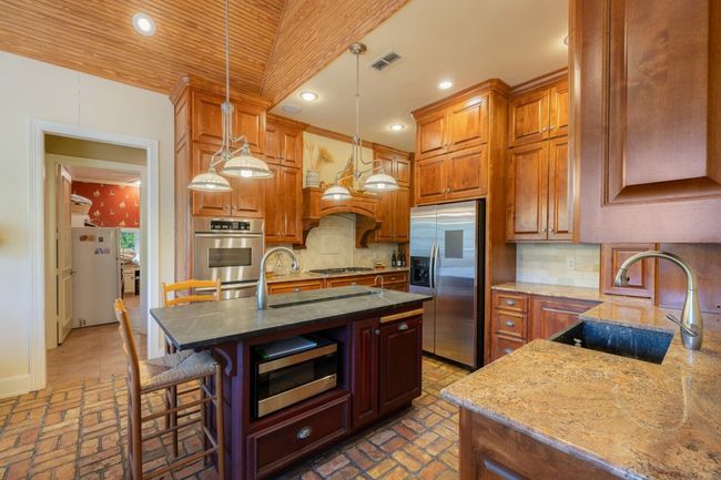 Kitchen featuring brick floor, stainless steel appliances, visible vents, and a sink | Image 20