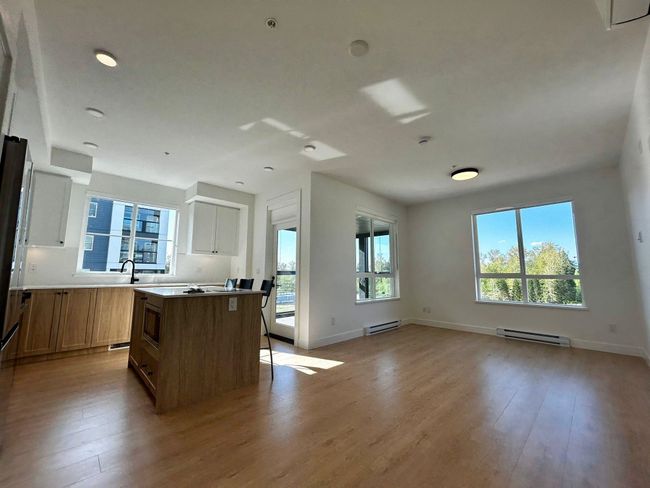 Kitchen with stainless steel microwave, light wood-style floors, a kitchen island, and a baseboard radiator | Image 5