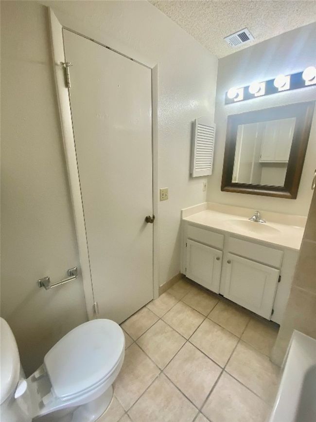 Bathroom featuring tile patterned flooring, vanity, toilet, visible vents, and a textured ceiling | Image 24