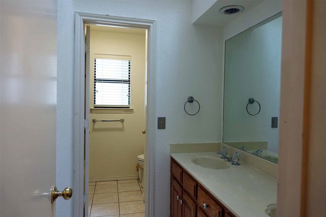 Bathroom with double vanity, toilet, and tile patterned flooring | Image 11