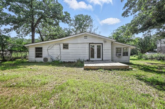 Rear view of property with french doors, a lawn, a deck, and cooling unit | Image 22