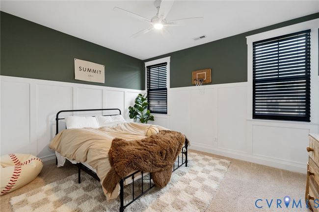 Bedroom featuring a decorative wall, wainscoting, carpet flooring, and ceiling fan | Image 32