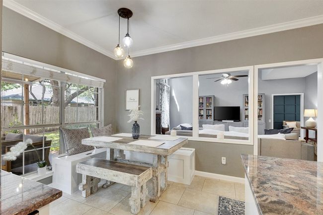 Dining room with ornamental molding, light tile patterned flooring, a ceiling fan, and baseboards | Image 8