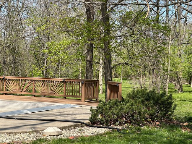 Partial view of the deck and wooded backyard. | Image 7