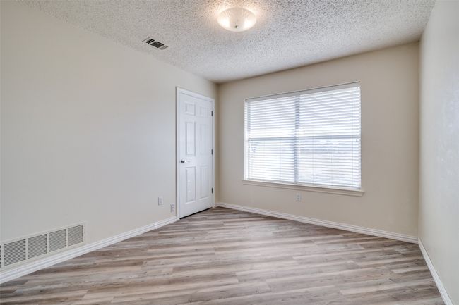 Spare room featuring a textured ceiling, baseboards, visible vents, and light wood-type flooring | Image 27