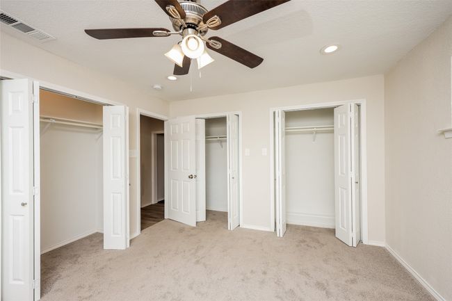 Unfurnished bedroom with two closets, light colored carpet, recessed lighting, and ceiling fan | Image 14