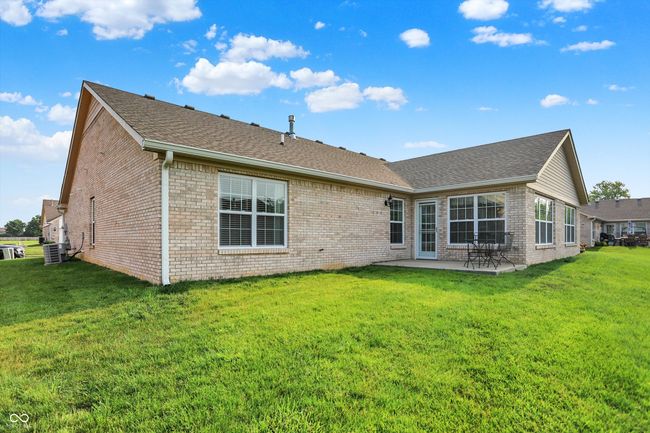 Back of property with brick siding, a patio, roof with shingles, and a lawn | Image 35