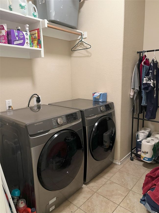 Laundry room featuring washing machine and dryer and light tile patterned floors | Image 12