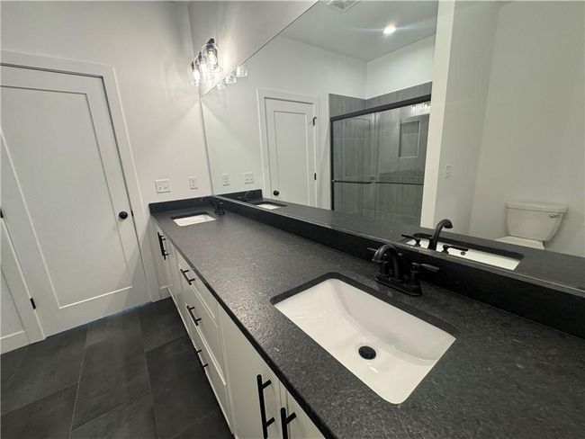 Full bath featuring double vanity, a sink, and a shower stall | Image 17