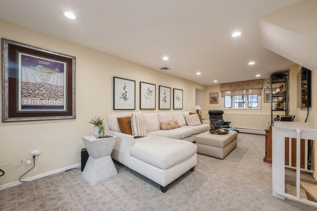 Living room featuring visible vents, baseboards, recessed lighting, light carpet, and a baseboard heating unit | Image 18