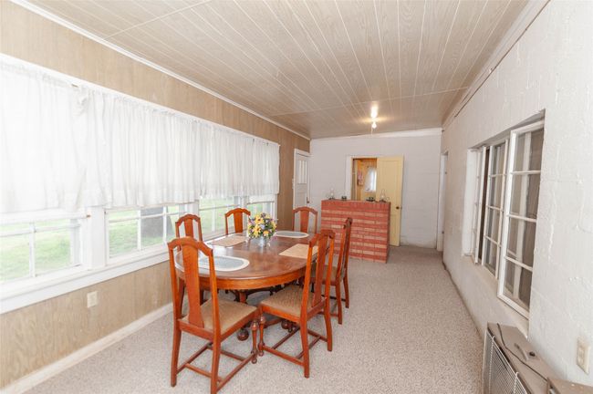 Dining area with wood walls and light colored carpet | Image 19