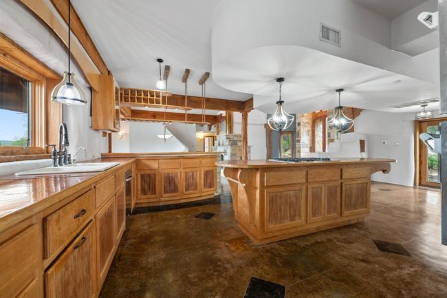 Kitchen featuring a sink, plenty of natural light, pendant lighting, and brown cabinets | Image 37