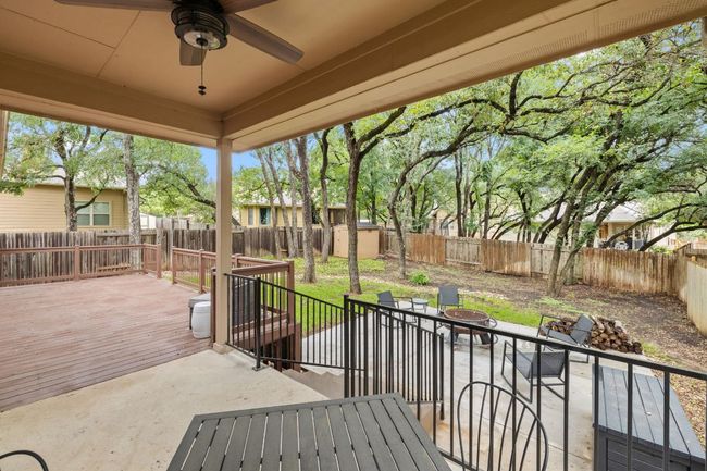 Fenced backyard featuring a shed, a deck, an outdoor fire pit, ceiling fan, and a patio area | Image 31