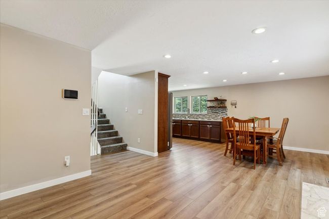 Dining area with light wood LVP floors, and recessed lighting. | Image 6
