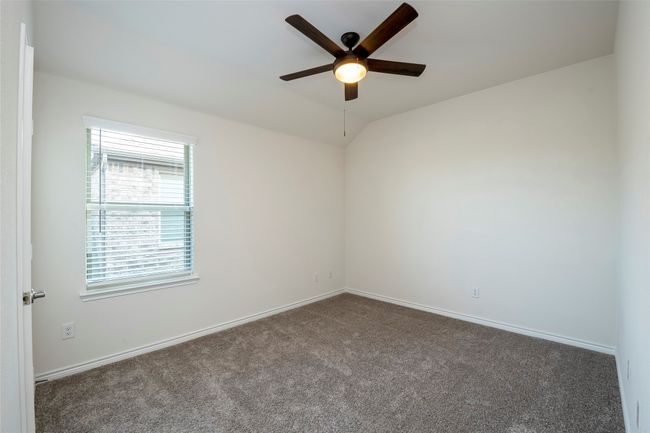 Carpeted empty room featuring vaulted ceiling and ceiling fan | Image 23